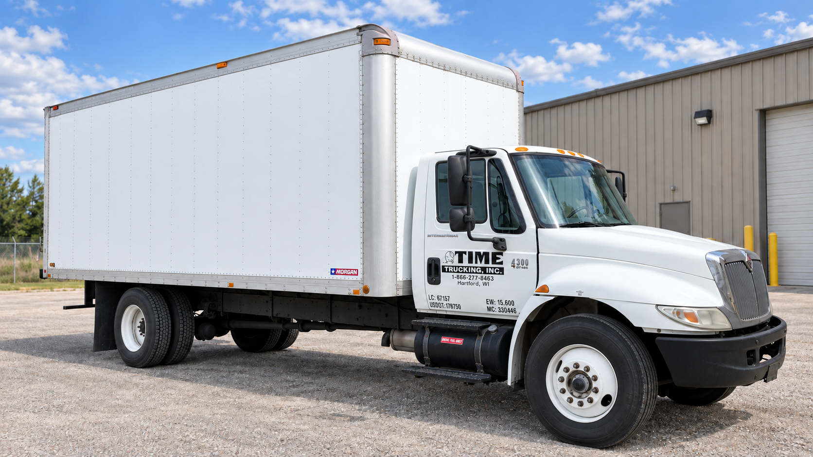White Time Trucking box truck outside an industrial building